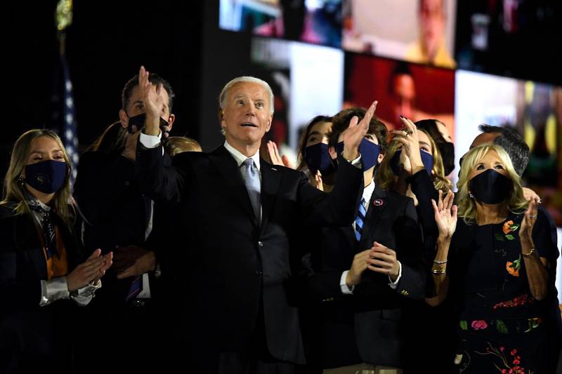 TOPSHOT - US President-elect Joe Biden with his wife Jill Biden, alongside family members, salute the crowd on stage after delivering remarks in Wilmington, Delaware, on November 7, 2020, and being declared the winner of the US presidential election. / AFP / Roberto SCHMIDT
