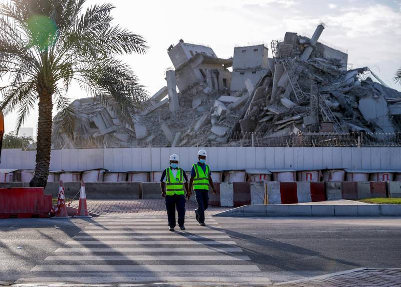Abu Dhabi, United Arab Emirates, November 28, 2020.  The surrounding areas the morning after the demolition of the Mina Zayed Plaza. Workmen cross the street.Victor Besa/The NationalSection:  National News