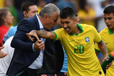 Brazil's Roberto Firmino celebrates with coach Tite. AFP