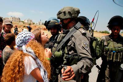 (FILES) This file photo taken on May 12, 2017 shows 17-year-old Ahed Tamimi (C) protesting before Israeli forces in the West Bank village of Nabi Saleh, north of Ramallah, on May 12, 2017, after a demonstration following Friday prayers in solidarity with Palestinian prisoners on hunger strike in Israeli jails.
Israel's army arrested Ahed Tamimi on December 19, 2017, after a video went viral of her slapping Israeli soldiers in the occupied West Bank as they remained impassive. / AFP PHOTO / ABBAS MOMANI