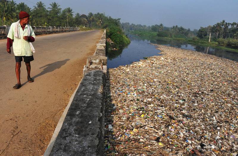 An Indian villager glances as plastic and other undissolvable wastes float over the polluted Vrishabhavathi River in the village of Kundanahalli of Ramnagaram District some 48 kms south of Bangalore on December 11, 2009. India like other emerging world economies is under pressure to make a gesture during the ongoing Copenhagen climate summit. India's per capita greenhouse gas emissions are expected to nearly triple in the next two decades from about 1.2 tonnes per person per year to 2.1 tonnes in 2020 and 3.5 tonnes in 2030, according to a recent government-backed report, which is still below the global average of 4.2 tonnes per person. But India's massive 1.1-billion population puts the country among the world's leading greenhouse gas emitters.    AFP PHOTO/Dibyangshu SARKAR (Photo by DIBYANGSHU SARKAR / AFP)