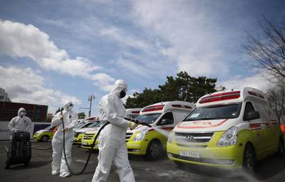 Emergency workers disinfect ambulances used for transferring the novel coronavirus Covid-19 patients in the south-east city of Daegu. EPA