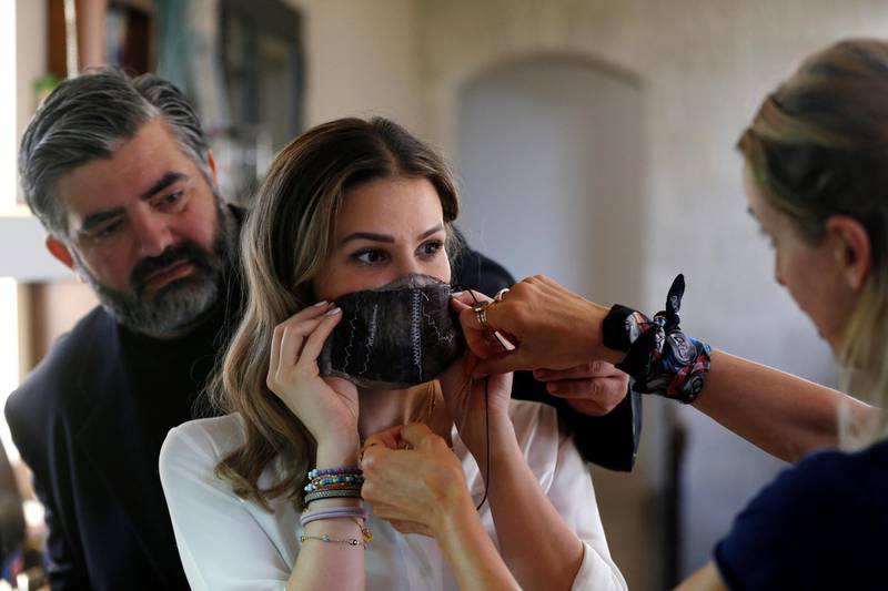 Jordanian chef Omar Sartawi and designers Princess Nejla Asem and Salam Dajani try on the masks. Reuters