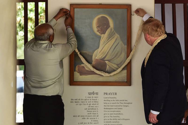 Boris Johnson is shown a painting of Mahatma Gandhi in Ahmedabad. AFP