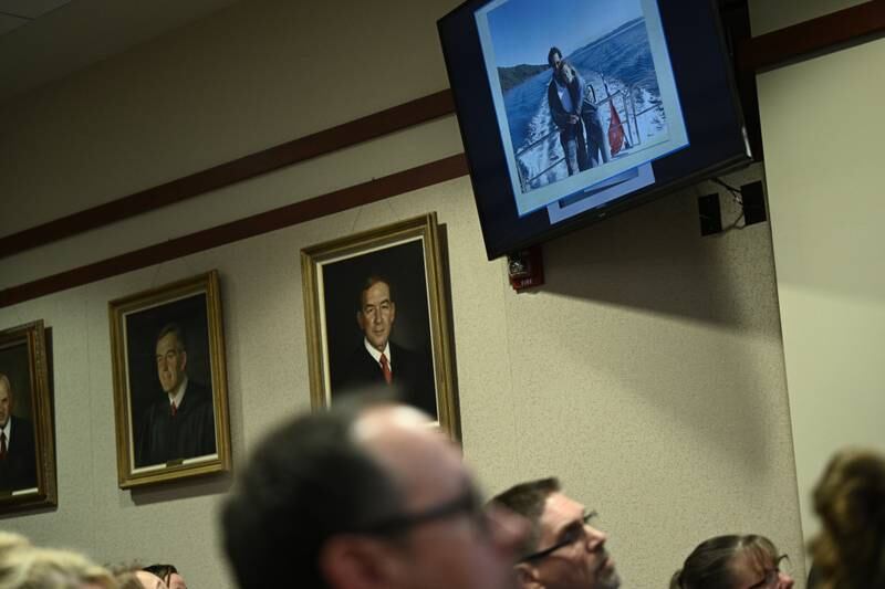 Courtroom observers watch a screen showing evidence. EPA