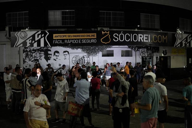 Fans gather outside the Vila Belmiro stadium, home of the Santos FC, to pay respect to Pele. AP