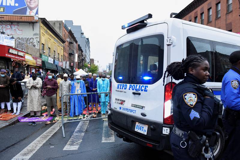 Police officers patrol as people perform prayers during Eid Al Fitr celebrations in Brooklyn, New York. Reuters