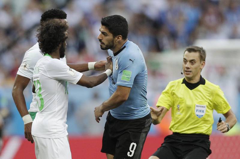 Saudi Arabia's Yasir Alshahrani and Ali Albulayhi push Uruguay's Luis Suarez. Andrew Medichini / AP Photo