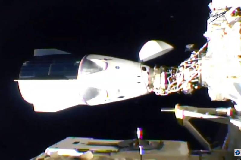 Nasa's SpaceX Crew-1 mission aboard the SpaceX Crew Dragon, right, is docked to the International Space Station. Nasa TV / AFP