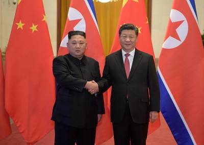 Kim Jong-un and Xi Jinping shake hands before talks at the Great Hall of the People in Beijing. AP Photo