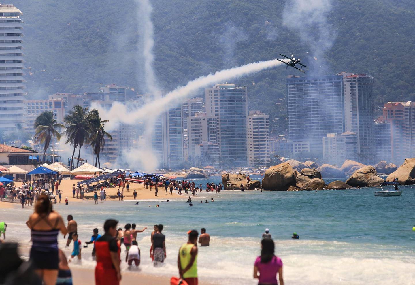 epaselect epa06942225 Tourists watch an airplane show in Acapulco, Guerrero, Mexico, 19 August 2018. Foreign pilots will perform again tomorrow during the opening of the Air Show Acapulco.  EPA/David Guzman
