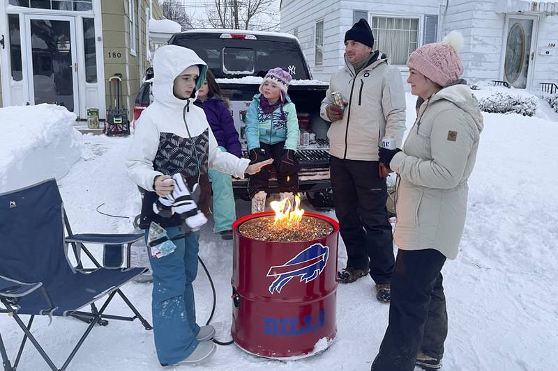 People gather around a fire pit after clearing snow in Buffalo. AP