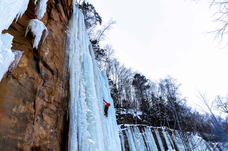 Susan Hill climbs on a rock wall covered with ice during Sandstone Ice Climbing festival at Robinson Ice Park in Sandstone, Minnesota on January 7, 2022.  (Photo by Kerem Yucel  /  AFP)