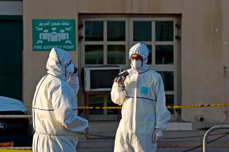 Bahraini policemen seal off a building housing foreign workers in the Salmabad industrial area as a precautionary measure after a resident tested positive for coronavirus (COVID-19), on the outskirts of the capital Manama on March 13, 2020.  / AFP / Mazen Mahdi
