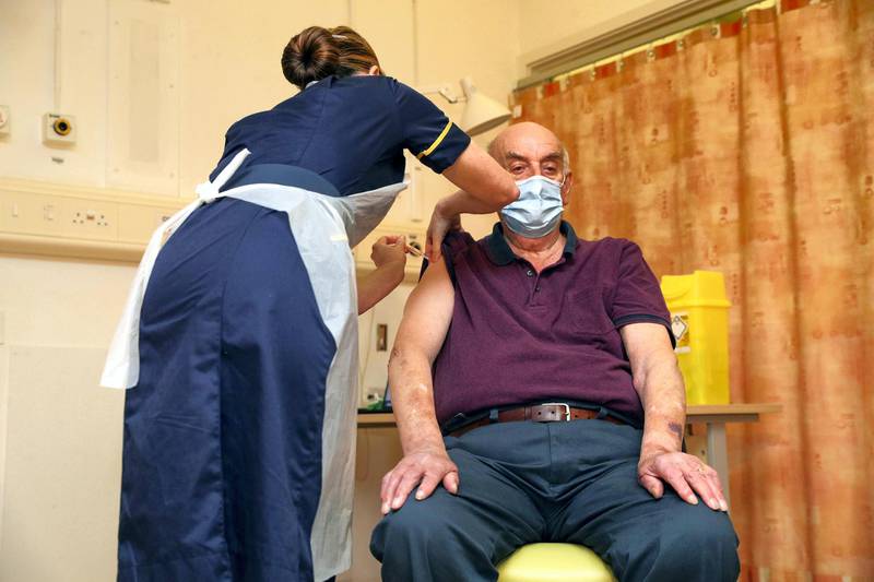 82-year-old Brian Pinker receives the Oxford University/AstraZeneca COVID-19 vaccine from nurse Sam Foster at the Churchill Hospital in Oxford, England, Monday, Jan. 4, 2021. Pinker, a retired maintenance manager received the first injection of the new vaccine developed by between Oxford University and drug giant AstraZeneca. (Steve Parsons/Pool Photo via AP)
