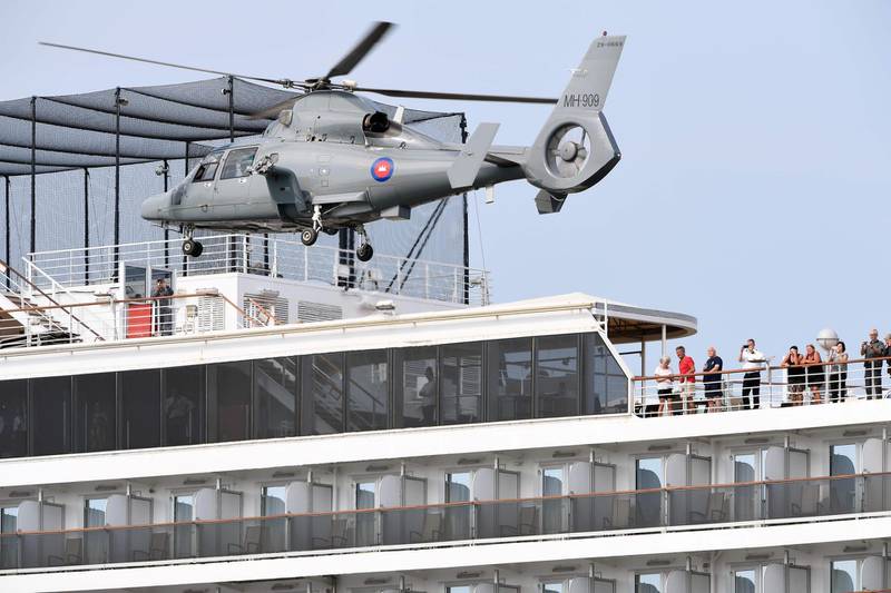 People on a deck of the Westerdam cruise ship watch a helicopter take off in Sihanoukville as authorities checked if any passengers that remained could have the COVID-19 coronavirus.  AFP