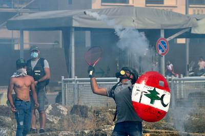 An anti-government protester uses a tennis racket to return a tear gas canister at riot policemen during a demonstration against the Lebanese government and worsening economic conditions in downtown Beirut, Lebanon.  EPA
