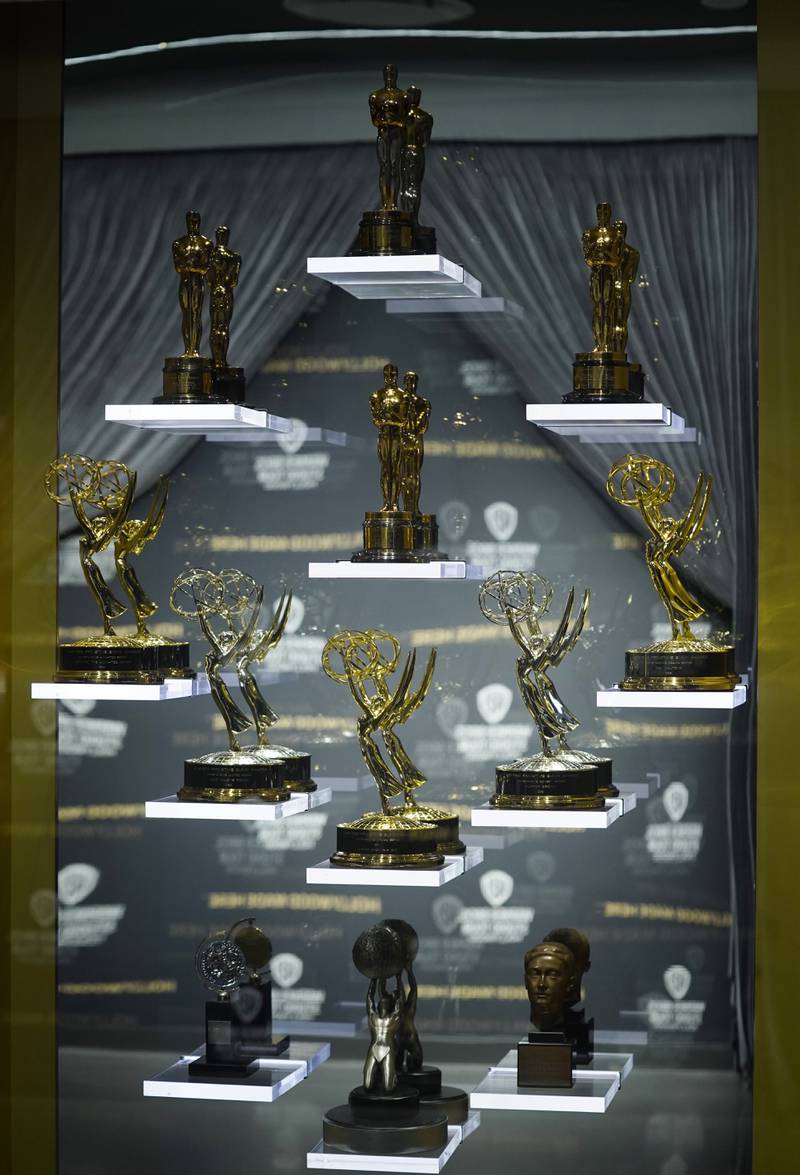 Oscar and Emmy statues for Warner Bros films and television shows are displayed behind glass in the Action and Magic Made Here interactive experience.