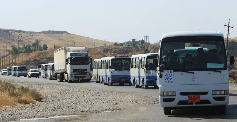 Buses carry Syrian displaced families, who fled violence after the Turkish offensive against Syria, to displacement camps on the outskirts of Dohuk, Iraq. REUTERS