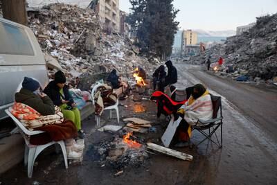 People keep warm by a fire as the search for survivors continues a week after the earthquake in Kahramanmaras, Turkey. Reuters