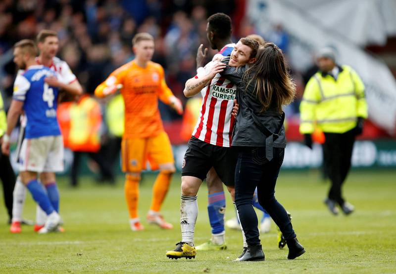 Sheffield United's John Fleck celebrates with a fan on the pitch after the match. Action Images