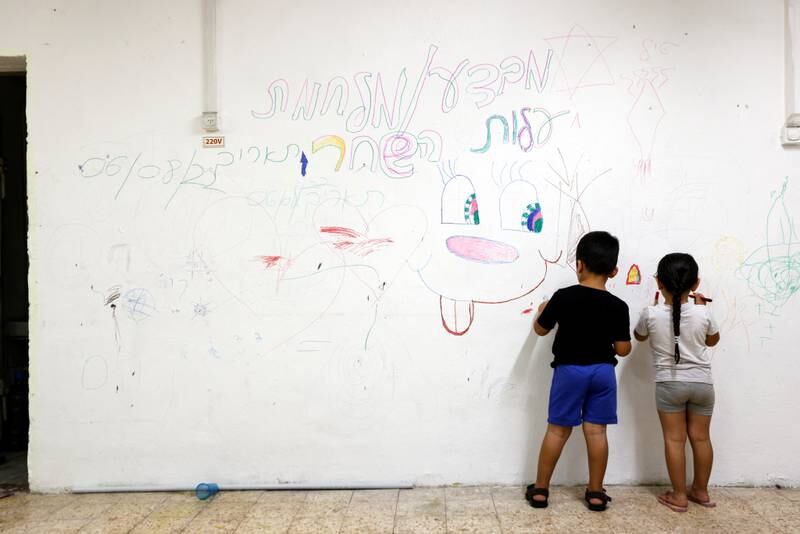 Israeli children draw on a wall as they stay with their family in a bomb shelter following rockets fired from Gaza towards Israel, in Ashkelon, Israel on Sunday. Reuters