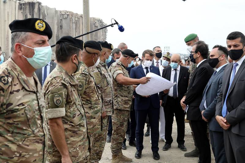 French Foreign Minister Jean-Yves Le Drian and French President Emmanuel Macron meet members of the military mobilised for the reconstruction of the port, in Beirut, Lebanon. Reuters