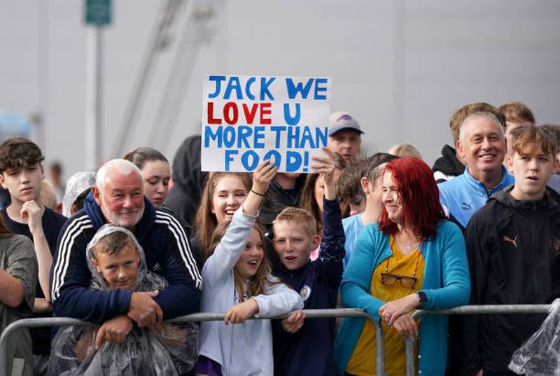 Manchester City fans wait for the arrival of Jack Grealish.