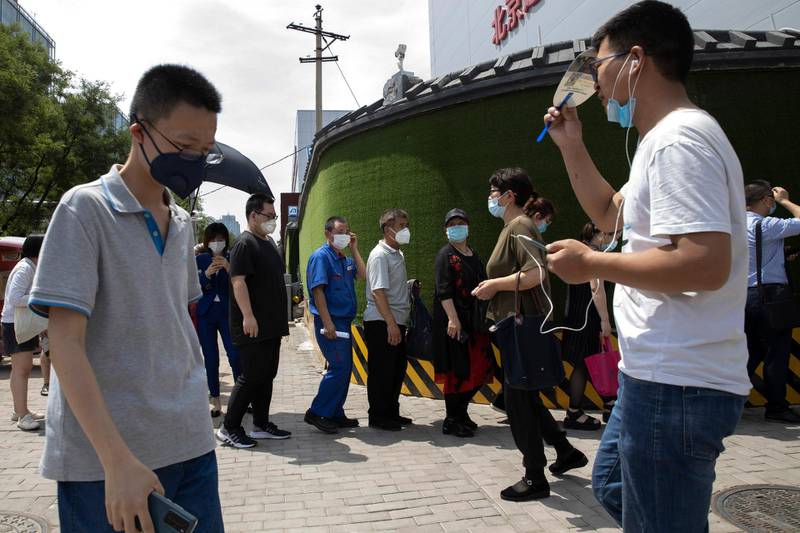 Residents wearing masks line up for a Covid-19 test outside the Worker's Stadium in Beijing on June 30. Test sites sprung up through the Chinese capital as frequent nasal swabs have become normal after the latest outbreak of the coronavirus. AP Photo