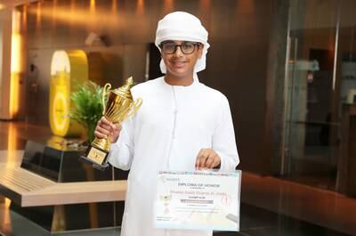 Khamis shows off his trophy and certificate in Abu Dhabi. Pawan Singh / The National