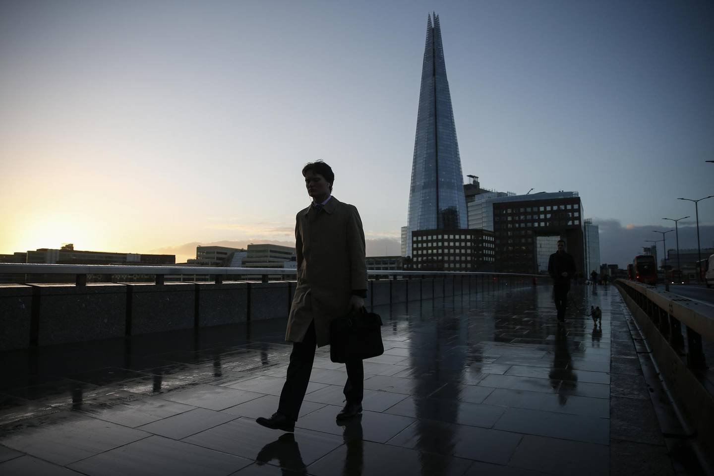 Commuters cross London Bridge in view of The Shard skyscraper in London, U.K., on Monday, Dec. 14, 2020. The topsy turvy trade talks between the U.K. and the European Union took another somersault on Sunday when Boris Johnson and Ursula von der Leyen gave negotiators another shot at closing a deal. Photographer: Hollie Adams/Bloomberg