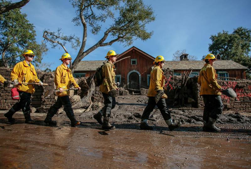 Rescue workers enter properties to look for missing people after the mudslide. Reuters