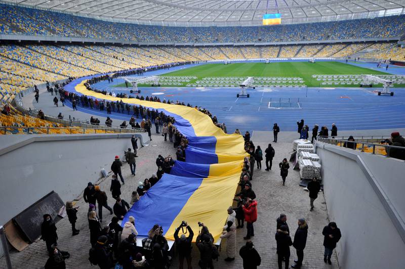 People carry a giant flag at a stadium to mark the 'Day of Unity' in Kiev. AFP