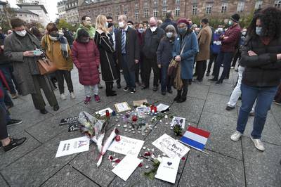 People stand near flowers and placards reading 'I am Samuel' and 'Don't touch my teacher' at a rally in Strasbourg. AFP