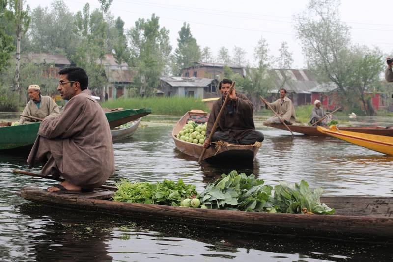 Farmers can typically be spotted squatting at the edge of their wooden shikara boats at the fruit and vegetable market on Dal Lake.  Priti Salian for The National