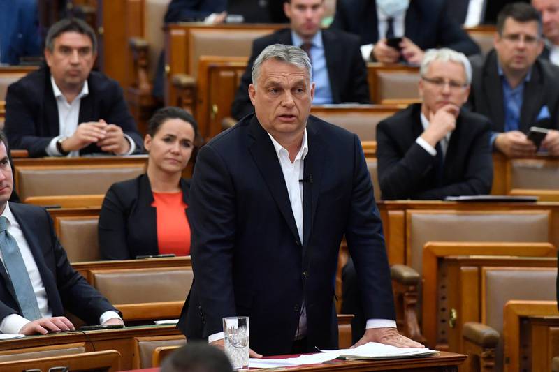 Hungarian Prime Minister Viktor Orban replies to an oppositional MP during a question and answer session of the Parliament in Budapest, Hungary, Budapest, Hungary, Monday, March 30, 2020. Hungary's parliament on Monday approved a bill giving Prime Minister Viktor Orban's government extraordinary powers during the coronavirus pandemic, without setting an end date for their expiration.  The bill was approved by Orban's Fidesz party and other government supporters by 137 votes in favor to 53 against. (Zoltan Mathe/MTI via AP)