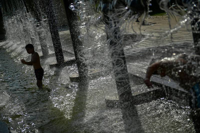 A young boy cools off in a fountain during a hot summer day, in Pamplona, northern Spain. AP
