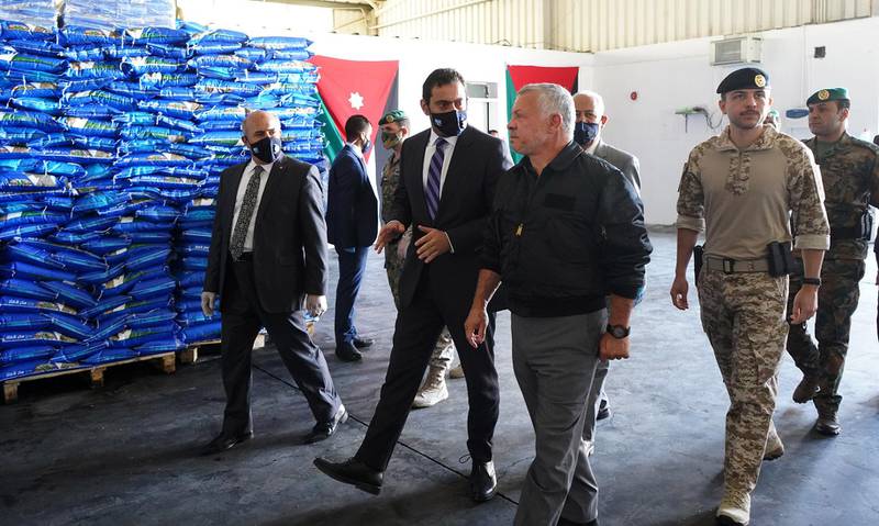 King Abdullah II and his son Crown Prince Hussein visit the Civil Service Consumer Corporation warehouses in Zarqa, in the northeast of Jordan, as part of preparation efforts against the Covid-19 pandemic.   AFP
