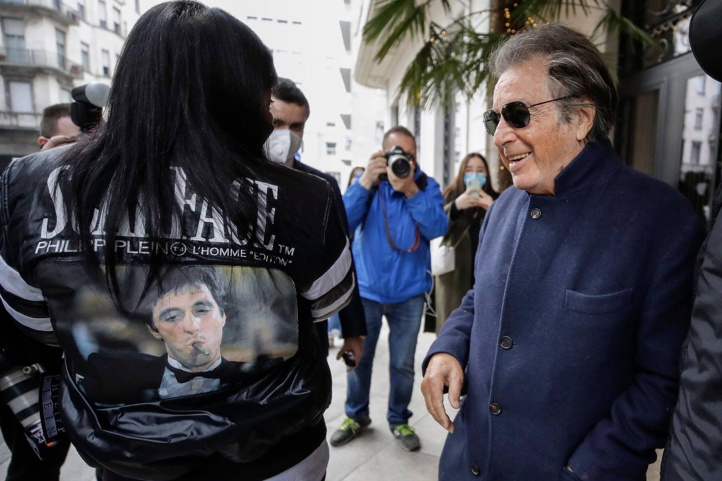 FILE - Al Pacino, who plays Aldo Gucci in Ridley Scott's movie based on the story of the murder of Maurizio Gucci in 1995, being filmed mainly in Milan and Rome, leaves Palazzo Parigi as Italian entrepreneur Stefania Nobile shows Pacino her leather jacket with the picture of the Scarface movie, in Milan, Italy, Thursday, March 11, 2021. The great-grandchildren of Guccio Gucci, who founded the luxury brand nearly a century ago in Florence, are appealing to filmmaker Ridley Scott to respect their familyâ€™s legacy in the film that focuses on the sensational murder. (AP Photo/Luca Bruno)