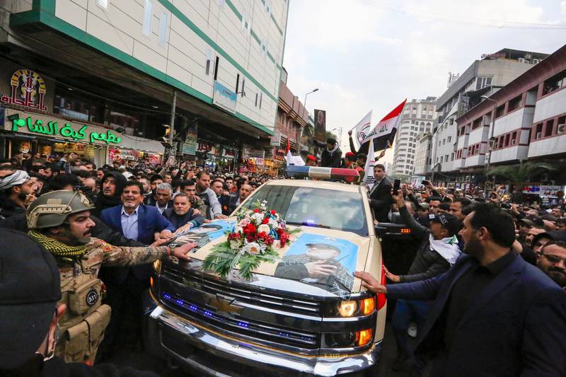 TOPSHOT - Mourners surround a car carrying the coffins of Iranian military commander Qasem Soleimani and Iraqi paramilitary chief Abu Mahdi al-Muhandis, killed in a US air strike, during their funeral procession in Kadhimiya, a Shiite pilgrimage district of Baghdad, on January 4, 2020. Thousands of Iraqis chanting "Death to America" joined the funeral procession Saturday for Iranian commander Qassem Soleimani and Iraqi paramilitary chief Abu Mahdi al-Muhandis, both killed in a US air strike. The cortege set off around Kadhimiya, a Shiite pilgrimage district of Baghdad, before heading to the Green Zone government and diplomatic district where a state funeral was to be held attended by top dignitaries. In all, 10 people -- five Iraqis and five Iranians -- were killed in Friday morning's US strike on their motorcade just outside Baghdad airport. / AFP / SABAH ARAR
