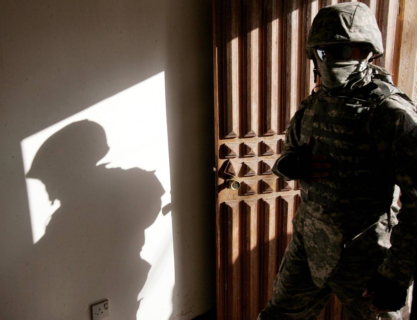 FILE PHOTO: An Iraqi interpreter enters a house during a patrol with U.S. army Alpha Company 1-64 Armored in the neighborhood of Adl in Baghdad November 7, 2007.   REUTERS/Stefano Rellandini/File Photo