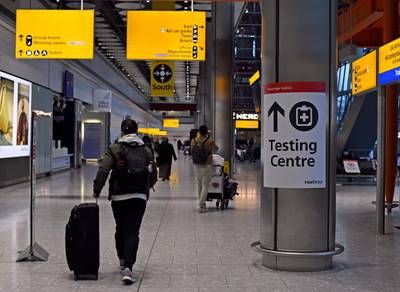 A passenger walks past a sign for the covid testing centre in the Arrival Hall of Terminal 5 at London's Heathrow Airport after arriving into the UK following the suspension of the travel corridors. Passengers arriving from anywhere outside the UK, Ireland, the Channel Islands or the Isle of Man must have proof of a negative coronavirus test and self-isolate for 10 days. Picture date: Monday January 18, 2021. (Photo by Kirsty O'Connor/PA Images via Getty Images)