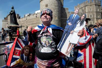 A royal family fan poses with memorabilia outside Windsor Castle. Will Oliver / EPA