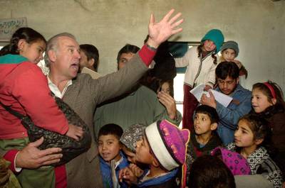 U.S. Sen. Joseph Biden, D-Del., Chairman of the U.S Senate's Foreign Relations Committee, waves as he talks to Afghan children during a visit to the Ariana primary school in Kabul, Jan. 12, 2002. AP Photo