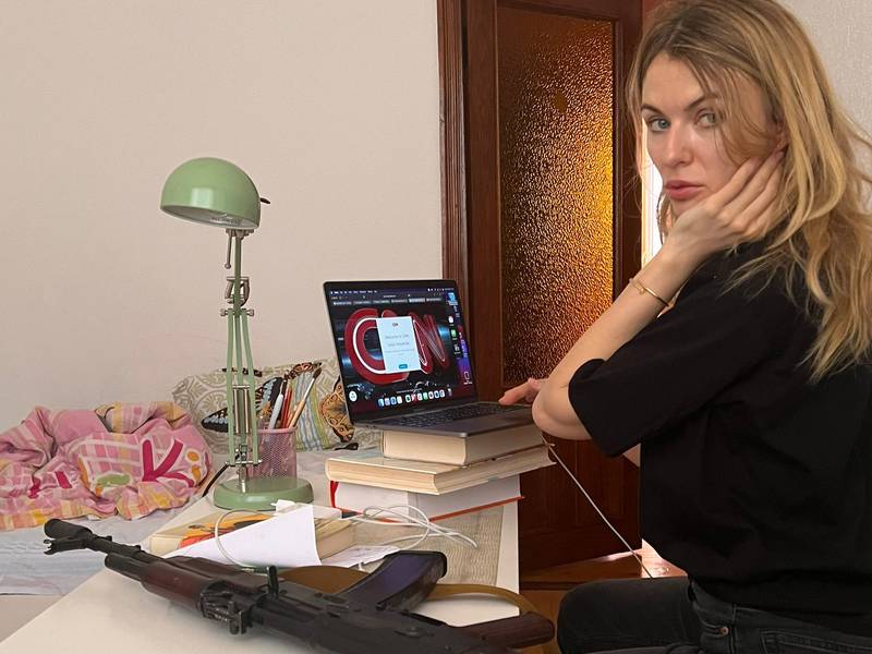 Lesia Vasylenko, a Ukrainian MP, works on her laptop while an AK-47 assault rifle rests next to her. She has vowed to defend her homeland against invading Russian forces. Photo: Lesia Vasylenko / Twitter