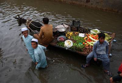 A vegetable vendor rides on his donkey cart through a flooded street after heavy monsoon rains in Pakistan's port city of Karachi.   AFP