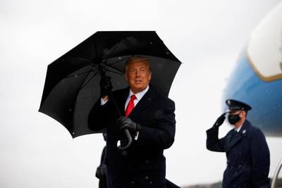 US President Donald Trump holds an umbrella as he arrives for a campaign a rally, at Oakland County International Airport, in Waterford Township, Michigan US.  Reuters