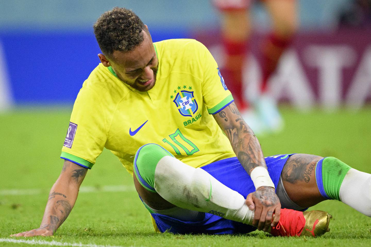 Brazil's Neymar grabs his ankle after an injury during the World Cup group G soccer match between Brazil and Serbia, at the the Lusail Stadium in Lusail, Qatar on Thursday, Nov.  24, 2022.  (Laurent Gillieron / Keystone via AP)