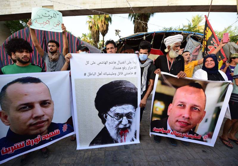 Iraqi protesters carry the picture of Iraqi terrorism expert Husham Al Hashimi with a slogan reading in Arabic 'Al Hashimi is the martyr of the October Revolution'. EPA