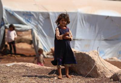 A displaced Syrian girl who fled from regime raids stands outside her tent in a camp in Kafr Lusin near the border with Turkey in the northern part of Syria's rebel-held Idlib province.  AFP
